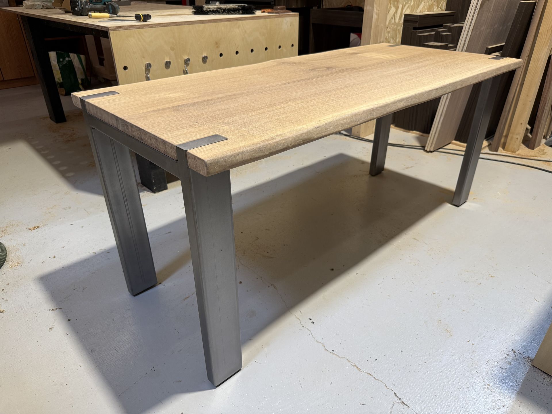 Mesa de comedor de roble y acero durante el montaje en taller